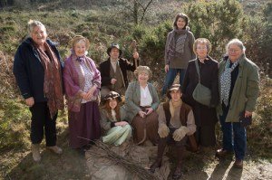 A group of people, most in nineteenth century rural costume but some in twenty first century garb