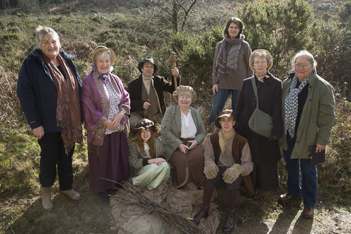 A group of people, most in nineteenth century rural costume but some in twenty first century garb
