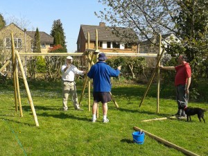 Three men putting together wooden frames