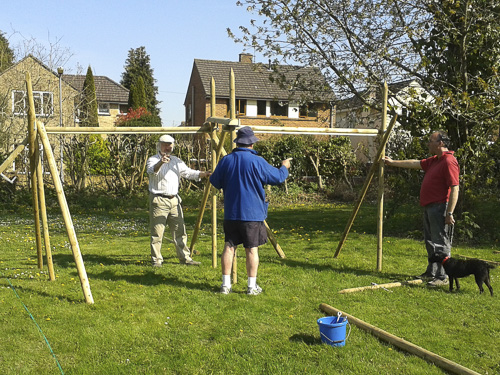 Three men putting together wooden frames