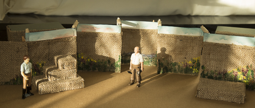 Model with two plastic figures, being a series of hurdles arranged to form a stage area